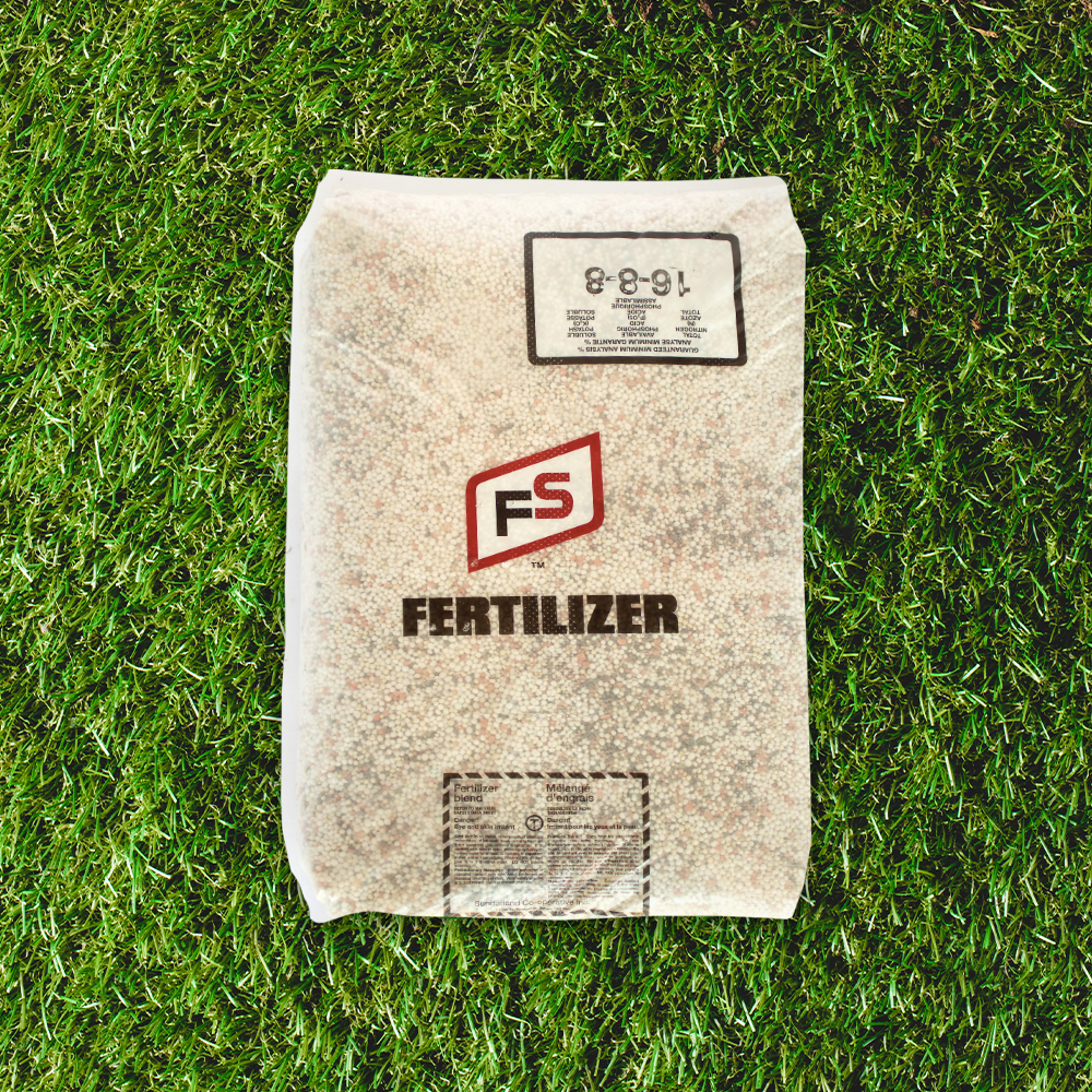 A bag of FS Fertilizer with a labeled composition rests on a grassy background.