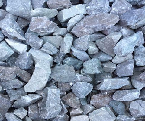 A close-up of a pile of variously sized gray and brown stones. The texture is rough, with irregular shapes and subtle color variations.