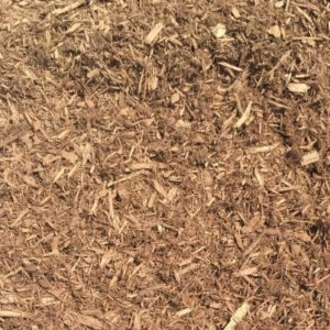 The image shows a close-up of brown wood chips or mulch spread across a surface, providing a textured, natural groundcover appearance.