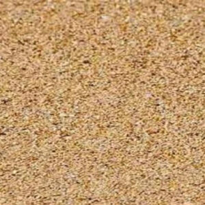 The image shows a close-up view of coarse, light brown sand, filling the entire frame with no visible landmarks or people.