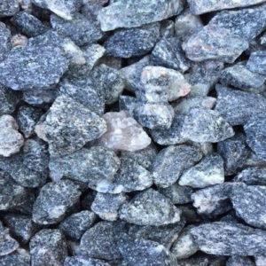 A close-up image of a pile of gray stones, showcasing various shapes and sizes, with textured surfaces and some lighter shades scattered throughout.